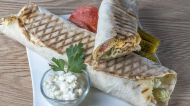 Shawarma tavuk sarması. Izgara et, peynir, lahana, havuç, sos ve yeşille doldurulmuş taze lavaş veya pita ekmeği. Geleneksel Doğu atıştırması.
