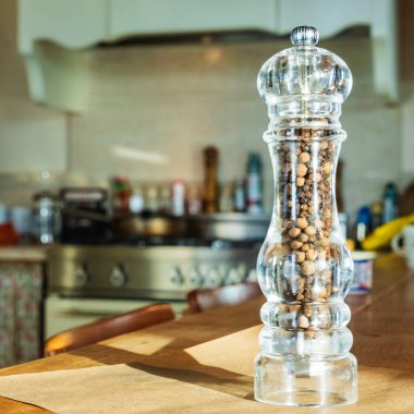 Güzel cam biberlik mutfak arka planındaki yünlü masada duruyor. Yemek teması.