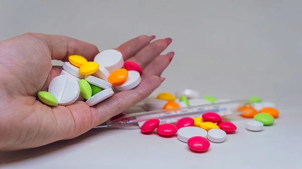 Молодая Женщина Держит Руках Много Таблеток Красных Таблеток Изолированы Сером — стоковое фото