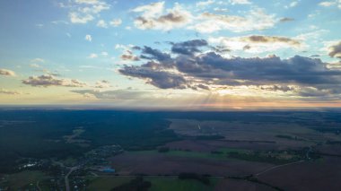 Güneşin ışığı gökyüzündeki bulutların arasından parlıyor. Tüylü bulutların şaşırtıcı bir şekilde gökyüzünde usulca hareket ediyor ve güneş bulutların arasında parıldıyor güzel ışınlar ve merceklerle..