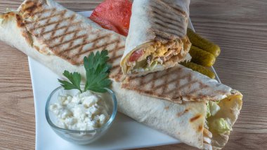 Shawarma tavuk sarması. Izgara et, peynir, lahana, havuç, sos ve yeşille doldurulmuş taze lavaş veya pita ekmeği. Geleneksel Doğu atıştırması.