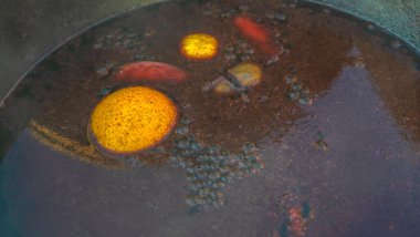 Sıcak sıcak şaraplı kazanlar. Sıcak şarap sokaktaki eski bir kazanda pişirilir. Açık ateşte yemek pişirmek. Yakın plan. Neşeli alkol içeceği..