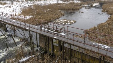 Küçük bir nehrin üzerinde eski bir köprü. Kırsal bölgedeki ilk kar. Metin için boşluk.
