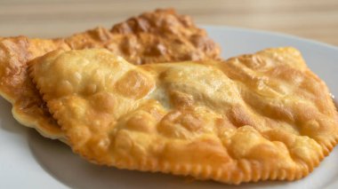 Beyaz tabakta et dolu ev yapımı börekler. Geleneksel Kafkas ve Rus mutfağı. Yemek kavramlarını yok et. Sokak yemekleri arka planı.