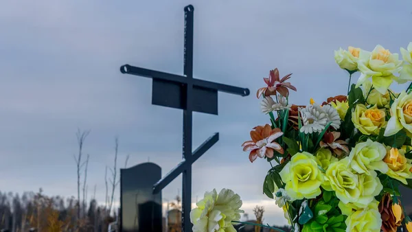 劇的な空の背景に人工的な花と金属墓のクロス 雪の冬の正教会の伝統的な墓地 テキストのスペース — ストック写真