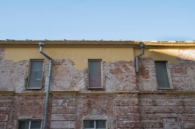 Duvarın bir kısmını kaplamayan eski duvar. Kırmızı tuğla ve sarı kaplamalı.