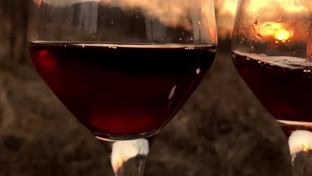 Einschenken von Rotwein in Weinglas mit Sonnenuntergang — Stockvideo