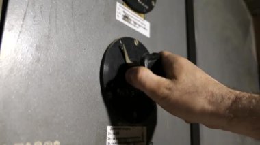 Bir adamın elinin eski bir kumanda anahtarını bir bitkiye çevirdiği yavaş çekim videosu.