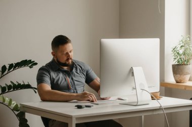 Bir adam uzaktan kumandalı bir bilgisayarla çalışıyor. Sakallı bir adam evdeki bir video konferansı sırasında okutman konuşmasını not alıyor. Bir öğretmen online bir derse hazırlanıyor..
