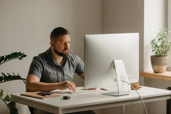 Hombre Trabaja Remotamente Una Computadora Escritorio Tipo Con Barba Está — Foto de Stock