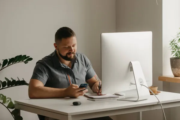 Hombre Sonriente Trabaja Remotamente Una Computadora Escritorio Tipo Con Barba — Foto de Stock