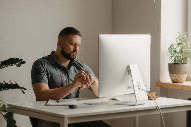 Bir adam uzaktan kumandalı bir bilgisayarla çalışıyor. Sakallı bir adam evdeki bir video konferansı sırasında akıllı bakışlarını kaydırıyor. Bir öğretmen online bir derse hazırlanıyor..