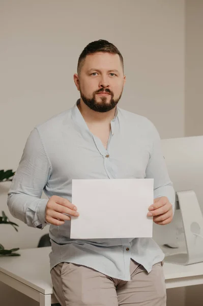 Homem Com Barba Está Sentado Com Uma Folha Vazia Papel — Fotografia de Stock