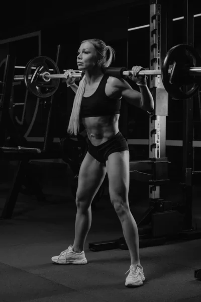 Una Mujer Deportiva Con Pelo Rubio Pone Cuclillas Con Una — Foto de Stock