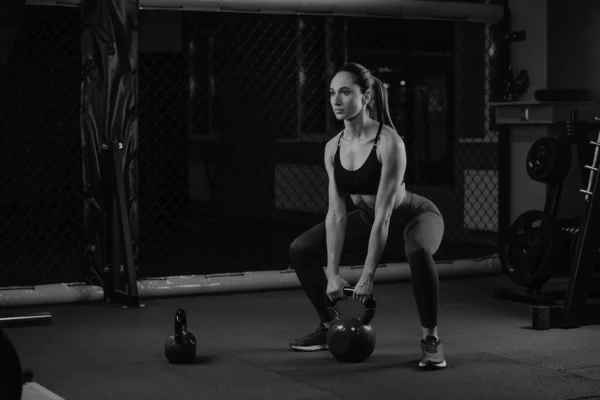 Una Donna Sportiva Dai Capelli Scuri Accovaccia Con Kettlebell Palestra — Foto Stock