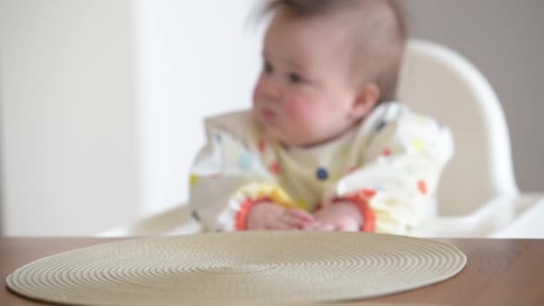 The hands put on the table dish in front of her infant 7-month girl — Stockvideo