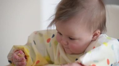 Çıplak elleriyle makarna ve ton balığı yiyen 7 aylık bir kızın yakın çekimi.