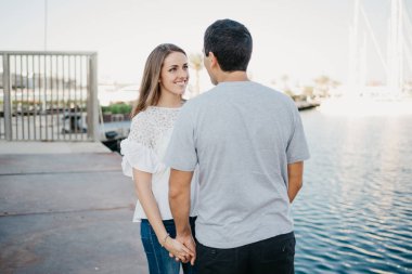 Şık bir adam ve esmer kız arkadaşı akşam İspanya 'da iskelede geziniyorlar. Valencia 'da randevusu olan iki turist..
