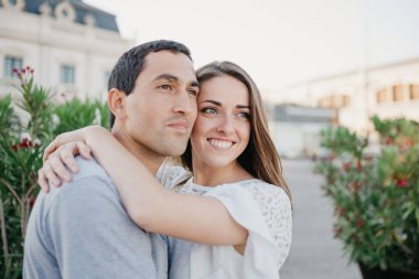 Gülümseyen esmer bir kadın, akşam İspanya 'daki iskelede İspanyol erkek arkadaşına sarılıyor. Valencia 'da randevusu olan iki turist.