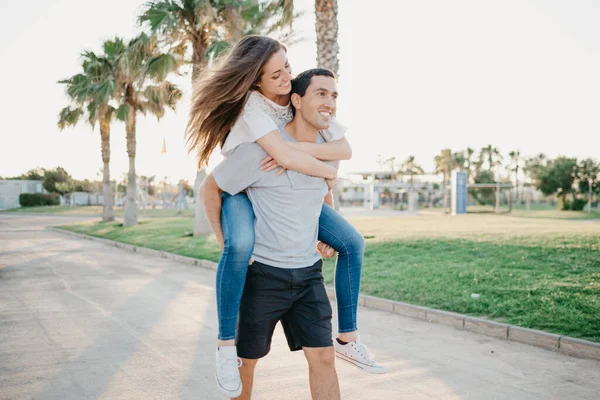 Uma Menina Morena Feliz Está Montando Seu Namorado Hispânico Entre — Fotografia de Stock