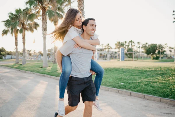 Uma Menina Morena Feliz Está Montando Seu Namorado Hispânico Rápido — Fotografia de Stock