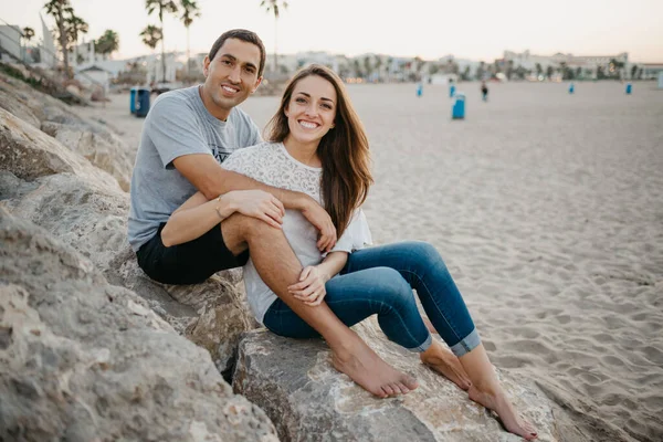 İspanya 'da bir dalgakıranın taşlarının üzerinde erkek arkadaşının bacaklarının arasında oturan bir kadın. Bir adam gün batımında karısına sarılıyor. Birkaç turist Valencia 'da poz veriyor..