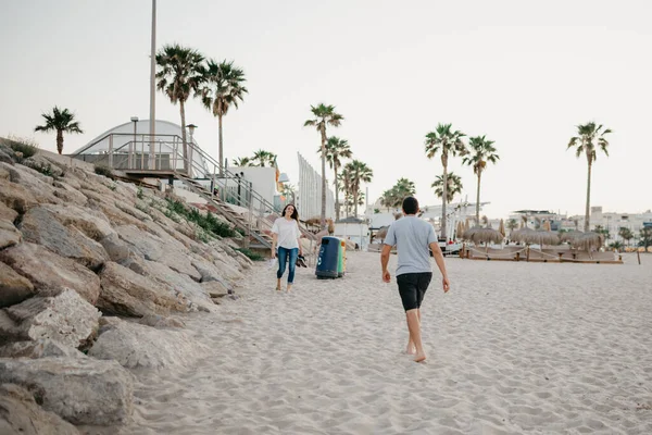 Akşamları İspanya 'da dalgakıran taşlarının yanında sahilde kız arkadaşına koşan bir adamın arkasından çekilmiş bir fotoğraf. Valencia 'da gün batımında bir çift turist..