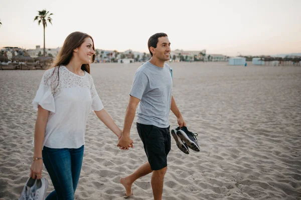 İspanyol bir adam ve gülümseyen kız arkadaşı akşam İspanya 'da kumlu bir plajda yürüyorlar. Bir çift turist Valencia 'da denize bakıyor..