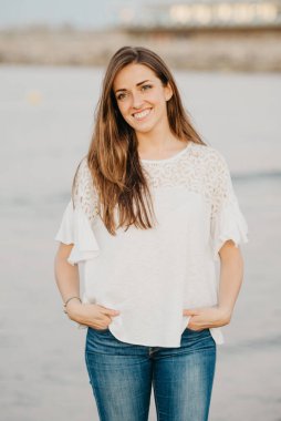 Genç bir kadın İspanya 'da alacakaranlıkta sahile yakın bir kumsalda poz veriyor. Valencia 'daki Balear Denizi yakınlarında bir kadın turist..