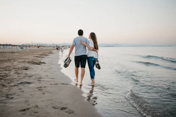 在西班牙 一张照片是一个男人和一个女人在沙滩上赤脚拥抱在一起的照片 两个游客在瓦伦西亚的巴利阿里海附近约会 — 图库照片