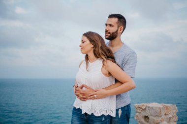 İspanyol bir adam akşamleyin İspanya 'daki parkta esmer karısının arkasından sarılıyor. Birkaç turist Valencia 'da gün batımında deniz manzarasının keyfini çıkarıyorlar..