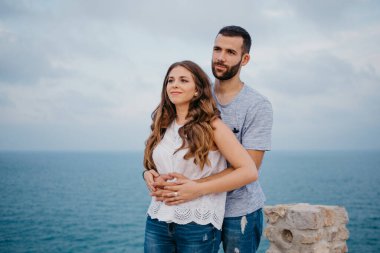 İspanyol bir adam akşamleyin İspanya 'daki Highland Park' ta esmer kız arkadaşının arkasından sarılıyor. Birkaç turist, Valencia 'da gün batımında deniz kenarında eğleniyorlar..