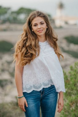 İspanya 'daki Highland Park' ın arka planında deniz feneri olan İspanyol bir kadın. Bir turist gün batımında Valencia 'da yürüyüş yapıyor..