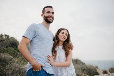 İspanyol bir adam akşam İspanya 'daki Highland Park' ta Latin kız arkadaşına sarılıyor. Birkaç turist, Valencia 'da gün batımında deniz kenarında eğleniyorlar..