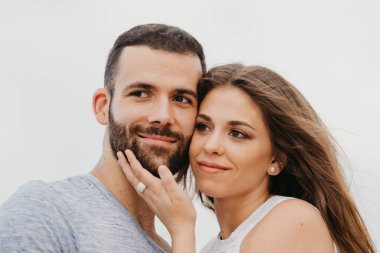 İspanya 'da bir dağ parkında kayalık deniz kıyısında birbirine sarılan İspanyol bir adamın ve gülümseyen kız arkadaşının yakın portresi. Valenci 'de bir çift mutlu turist