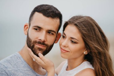 İspanya 'da bir dağ parkında kayalık deniz kıyısında birbirine sarılan İspanyol bir adamla Latin kız arkadaşının yakın portresi. Valencia 'da bir çift mutlu turist