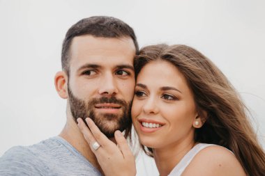 İspanya 'da bir dağ parkında kayalık deniz kıyısında birbirine sarılan İspanyol bir adamın ve gülümseyen kız arkadaşının yakın portresi. Valenci 'de bir çift mutlu turist