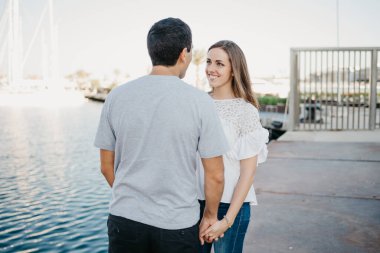 Şık bir adam ve esmer kız arkadaşı akşam İspanya 'da iskelede geziniyorlar. Valencia 'da randevusu olan iki turist..