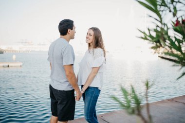 İspanyol stil sahibi bir adam akşamleyin İspanya 'daki iskelede esmer kız arkadaşının elini tutuyor. Valencia 'da randevusu olan iki turist..