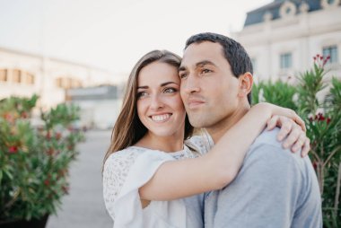 Gülümseyen esmer bir kadın, akşam İspanya 'daki iskelede İspanyol erkek arkadaşına sarılıyor. Valencia 'da randevusu olan iki turist.