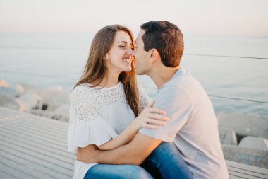 İspanyol bir adam, gülümseyen esmer kız arkadaşıyla İspanya 'da bir dalgakıranda oynaşıyor. Valencia 'da gün batımında bir çift turist..