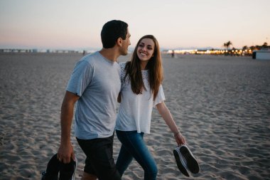 İspanyol bir adam ve kız arkadaşı akşam İspanya 'da Balearic Denizi yakınlarında kumlu bir plajda yürüyorlar. Valencia Alacakaranlık 'ta buluşan mutlu turistler..