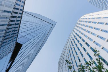 Öğlen gökdelenler arasındaki gökyüzü manzarası. Finans bölgesindeki modern ofis binaları. Şehrin merkezindeki cam kuleler. Bir yığın yüksek bina..