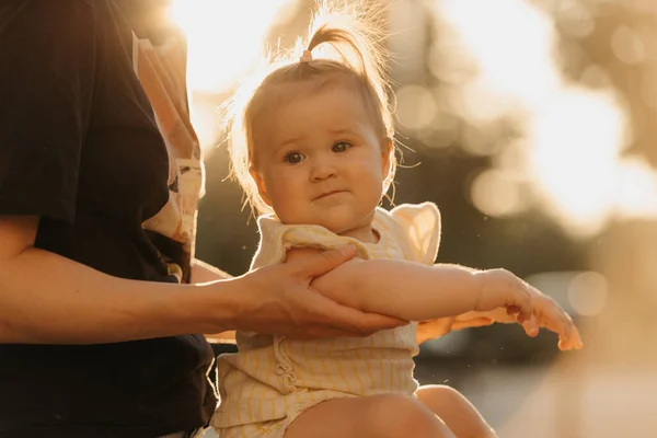 햇빛을 엄마의 안기는 아기의 사진이다 어머니는 공원에서 팔꿈치를 — 스톡 사진