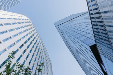 Öğlen gökdelenler arasındaki gökyüzü manzarası. Finans bölgesindeki modern ofis binaları. Şehrin merkezindeki cam kuleler. Bir yığın yüksek bina..