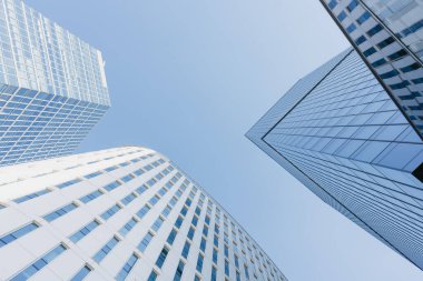 Öğlen üç gökdelen arasındaki gökyüzü manzarası. Finans bölgesindeki modern ofis binaları. Şehrin merkezindeki cam kuleler. Bir yığın yüksek bina..