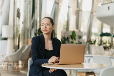 Ceketli bir kadın emlakçı müşteri bekliyor. Bir kadın masada oturuyor ve modern lobide çalışıyor. Bir kadın bilgisayar geliştiricisi, çağdaş bir ofis içinde dizüstü bilgisayarın yanında dinleniyor.