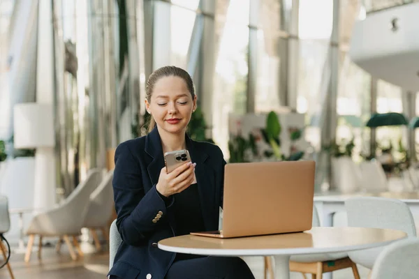 Egy Női Ingatlanügynök Egy Blézerben Híreket Olvas Egy Mobiltelefon Képernyőjén — Stock Fotó