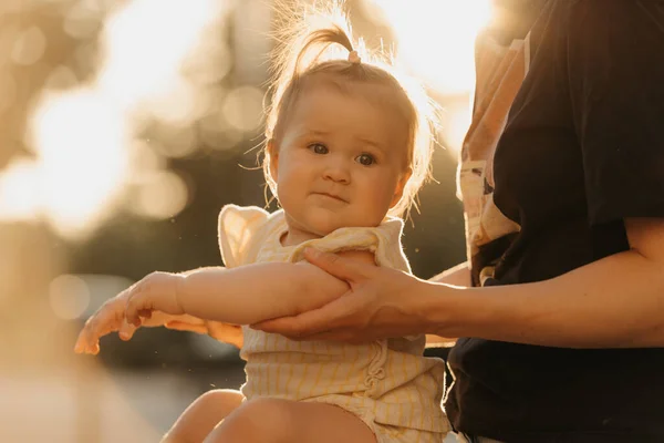 햇빛을 엄마의 안기는 아기의 사진이다 어머니는 공원에서 팔꿈치를 — 스톡 사진