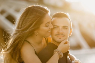 İspanya 'da günbatımında modern kentsel alanda erkek arkadaşına sarılan bir kızın yakın bir fotoğrafı. Akşam Valencia 'da randevusu olan bir çift turist..
